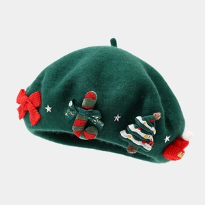 Detail of dark green wool beret with red bow, candy cane and Christmas tree ornaments
