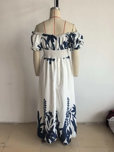 Détail d'une robe longue blanche à épaules dénudées avec imprimé feuilles bleues
