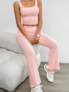 Close-up of pink sleeveless knit top and high-waisted casual pants set on a woman