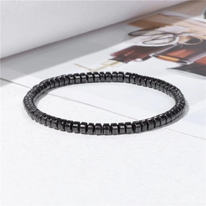 Classic hematite beaded bracelet with metallic gray shine on minimalist background