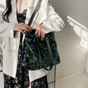 Sparkly dark teal sequin bucket bag for women with black straps in professional studio shot