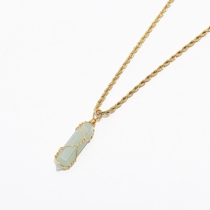 Detailed macro view of the hand-wrapped light green crystal pendant on a gold twisted rope chain