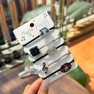 Détail d'élastiques à cheveux musicaux avec notes et disques sur une carte de présentation