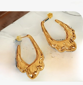 Macro shot of 18K gold plated hoop earrings with irregular lava fluid texture design