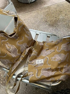 Détail du sac cabas en toile à imprimé léopard avec étiquette tissée sur chaise