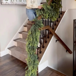 Realistic Norfolk pine garland wrapped on a staircase for festive Christmas home decor