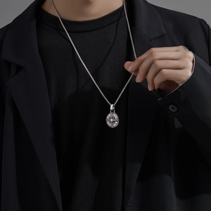 Men's retro silver compass pendant with box chain on model in black formal outfit