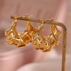 Detailed macro view of 18K gold-plated hollow hoop earrings with stylish ripple textures