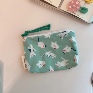 Close-up of mint green cotton coin purse with white cartoon cat prints and zipper