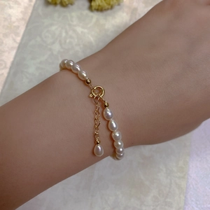 Detailed view of natural Baroque pearl bracelet with 14K gold plated clasp on wrist