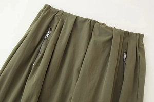 Gros plan du pantalon vert armée avec taille élastique et poches à fermetures éclair en métal