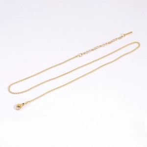 Detailed view of a golden stainless steel bead chain with lobster clasp and extender