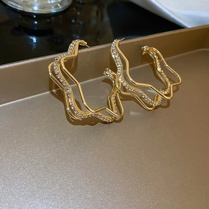 Three-layer gold metal earrings with sparkling rhinestones and abstract wave design