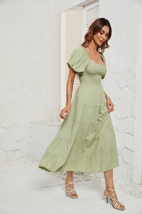 Détail de la robe longue étagée vert sauge avec bustier froncé et manches bouffantes