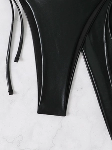 Detail view of black glossy synthetic leather bikini bottom with sleek side straps