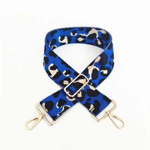 Close-up of leopard print bag strap with royal blue fabric and gold metal buckles