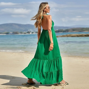Sexy backless halter maxi dress in green for beach vacation featuring a flowing skirt