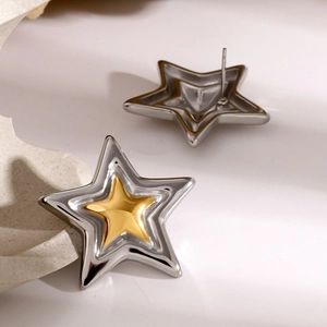 Detailed view of two-tone star earrings showing silver and gold layers with back posts
