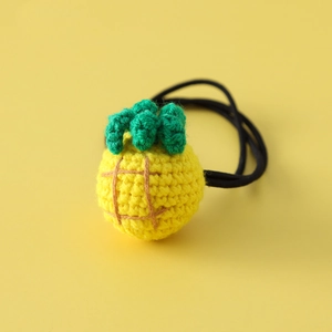 Handmade crochet pineapple hair tie for girls on a vibrant yellow background