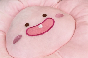 Gros plan du tissu de coussin tournesol en peluche rose avec broderie détaillée