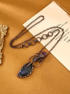 Détail macro du pendentif labradorite et améthyste avec chaîne en bronze antique