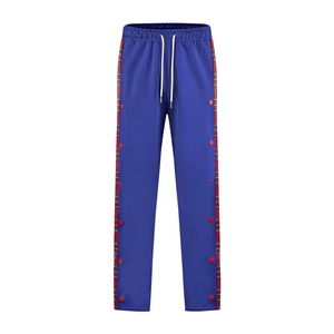 Detail view of royal blue joggers featuring side red plaid panels and snap buttons