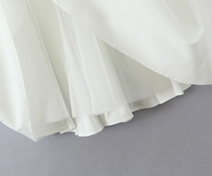 Detail view of the white tiered tulle lining and double-layered fabric for dress volume