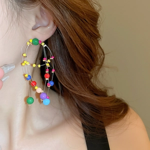 Macro shot of colorful layered resin beaded hoop earrings with vibrant geometric drop details