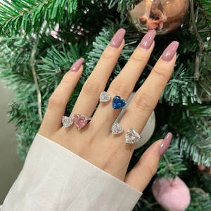 Detailed view of silver heart rings with blue and pink stones on a festive background