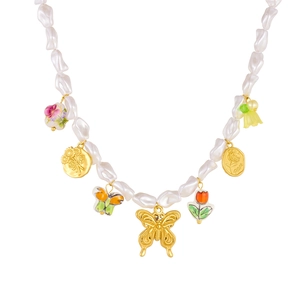 Baroque pearl necklace featuring gold butterfly pendants and ceramic floral charms