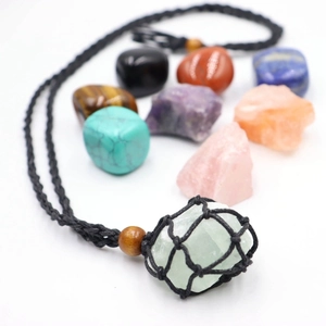 Close-up of handmade woven mesh pouch necklace with a natural green crystal pendant
