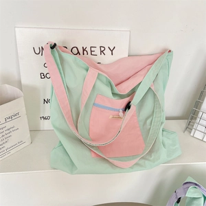 Detail of mint green and pink patchwork canvas tote bag with functional front zipper pocket