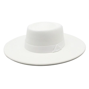 Detail of white wool wide brim boater hat with matching ribbon and flat top design