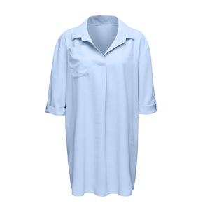 Detalle de vestido camisero de gasa azul claro con cuello en V y mangas enrollables