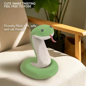 Snake shaped cat plush toy with green corduroy texture on a light wooden chair