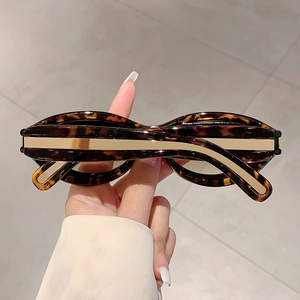 Detail of tortoise shell sunglasses with wide gold metal accent on the temple arm