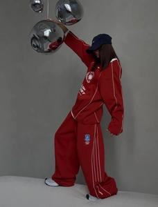 Detail of red oversized sweatshirt and matching wide-leg joggers with letter print design