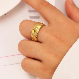 Chic wide gold stainless steel ring with star and eye patterns on model's finger