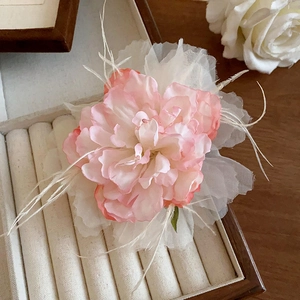 Detail of pink gradient rose hair claw with delicate white mesh and feather accents