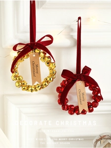 Christmas bell wreath with red velvet bow and Merry Christmas tag on a white wall