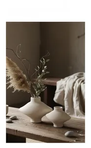 Détail de vases en céramique crème mate en deux tailles sur un socle en bois