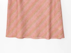 Detail shot of linen skirt featuring pink and olive green diagonal stripe pattern and fabric texture