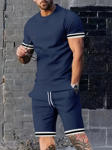 Detail of navy blue men's sport set showing striped cuffs on t-shirt and shorts