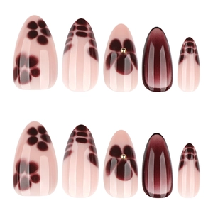 Short almond press-on nails with burgundy gradient, leopard print, and gold stud accents