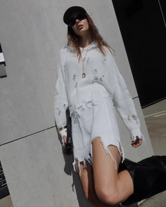 Gros plan d'une robe en maille blanche vieillie avec texture déchirée et coupe oversize