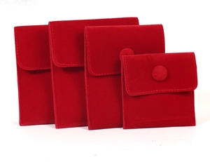 Detailed view of four red velvet jewelry pouches in various sizes with snap closures