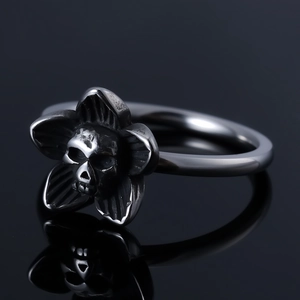 Gothic punk skull flower ring in vintage silver finish on black reflective surface