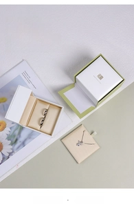 Detailed top view of matcha green silk jewelry box set with rings and bow pendant
