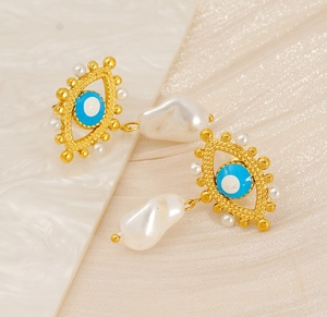 Detail of evil eye stud earrings featuring baroque pearls and blue enamel detailing