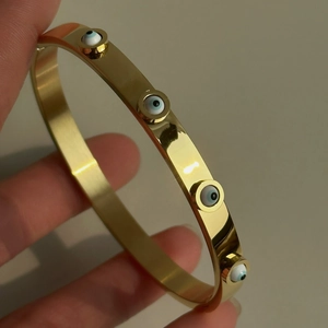 Brazalete de acero chapado en oro 18k con dijes de ojo turco azul y circonitas